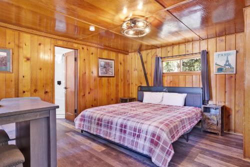 Un dormitorio con una cama en una habitación con paredes de madera. en Big pines #103, en Big Bear Lake