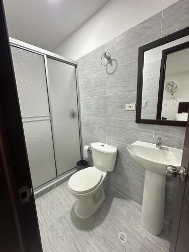 a bathroom with a toilet and a sink at Santa Elena Hotel in Ocaña