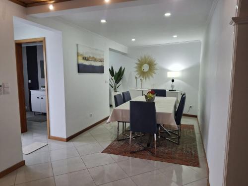 a dining room with a white table and chairs at Casa da Boa Vista in Maia