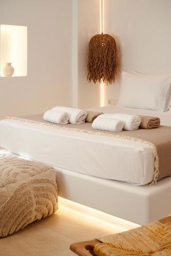 two beds in a white room with towels on them at Ayana in Naxos Chora