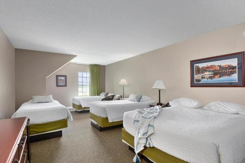 una habitación de hotel con 3 camas. en Top Floor Family Deluxe Bay View, en North East