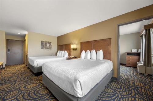 a hotel room with two beds and a television at Best Western Woodburn Inn in Woodburn