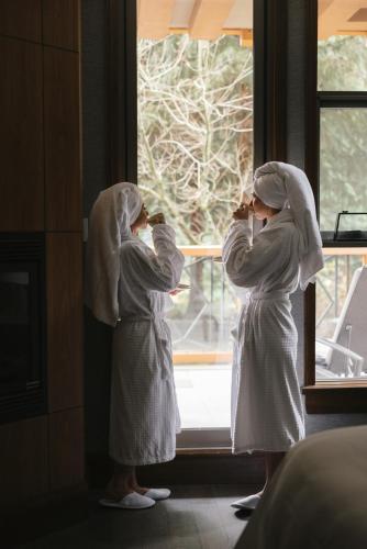 two women in robes looking out of a window at Four Seasons Resort Whistler in Whistler