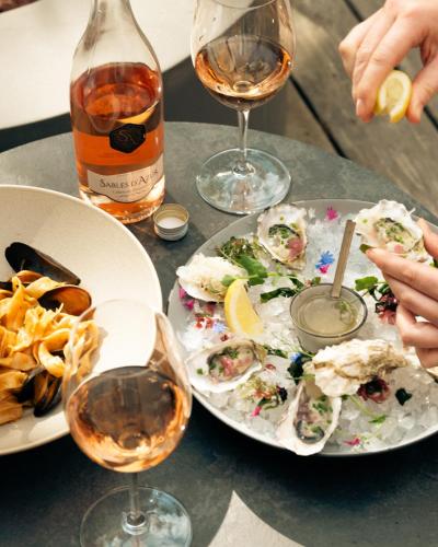 a table with plates of food and two glasses of wine at Four Seasons Resort Whistler in Whistler