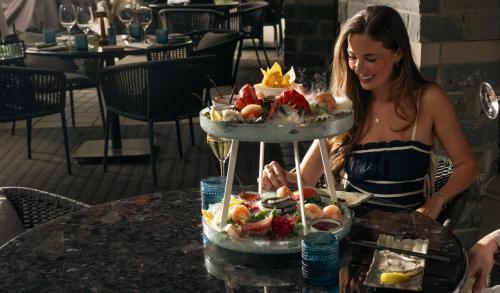 a woman standing at a table with a tray of food at Four Seasons Resort Whistler in Whistler