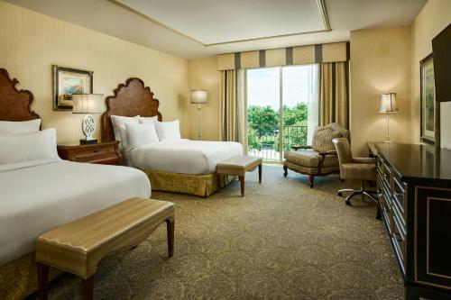 a large hotel room with two beds and a window at Woolley's Classic Suites in Aurora