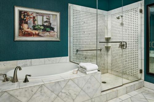 a bathroom with a bath tub and a shower at Woolley's Classic Suites in Aurora