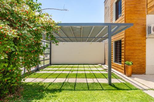 a pergola in the backyard of a house at Departamentos Brown in San Rafael