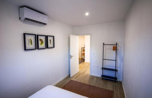 a room with a white wall with two pictures on it at Casa Alba - The Natural Lodgings and Retreats in Alter do Chão