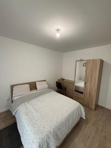 a white bedroom with a bed and a mirror at Studio Bethel cosy à Villejuif centre Paris in Villejuif