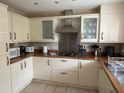 a kitchen with white cabinets and a stove top oven at Bethel Haven in Great Oakley