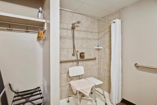 y baño con ducha y silla blanca. en Top Floor East Handicap Accessible, en North East
