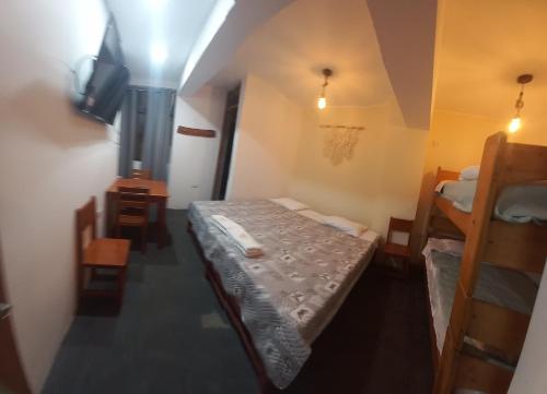 a small room with two bunk beds and a television at Hospedaje velilu in Ica