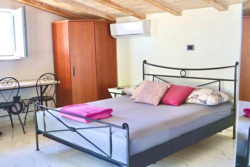 a bedroom with a bed with purple and pink pillows at GV - Holiday home with MagnaPool in Makarska