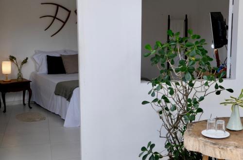 a bedroom with a bed and a table with a plant at Restaurante & Pousada Gaivota in Santo André