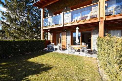 a house with a patio with a table and an umbrella at Planta Baja con jardín y piscina junto a Llivia in Estavar