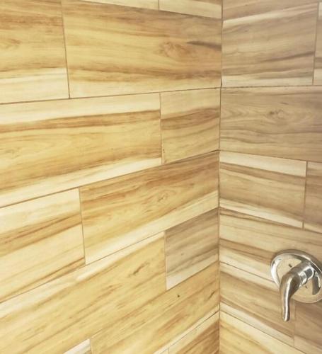 a bathroom with a shower with a wooden wall at Great Looking Studio Apartment in New York