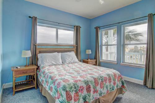 a blue bedroom with a bed and two windows at Casa Las Palmas - Pet Friendly! Boardwalk to the Beach! in Mustang Beach