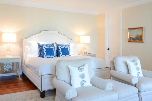a white bedroom with a large bed with blue pillows at 5 Bedroom Wilson Village Home 61 in Bluffton