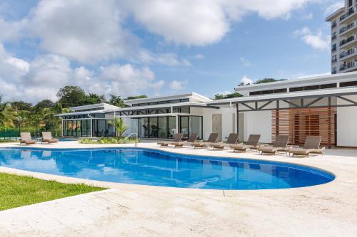 a house with a swimming pool next to a building at Viva Jaco in Jacó