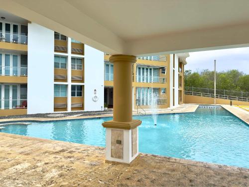 a large swimming pool in a building with a column at Oceanview Costa del Mar Condo with Pool and Smart TV in Pole Ojea