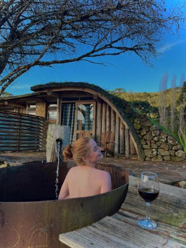 a woman sitting in a tub with a glass of wine at Divina Reserva Capim limão in Bom Retiro