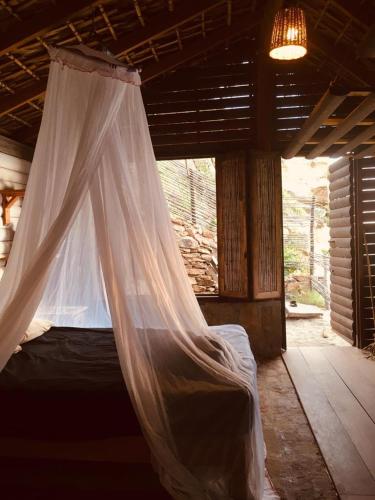 a bed with a mosquito net in a room at Oceanfront cabin in Playa Mermejita Mazunte in Mazunte