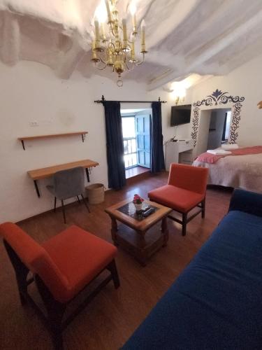 a room with a bed and two chairs and a table at k'uychi Wasi in Cusco