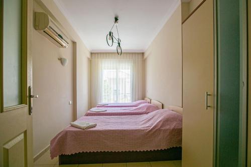 a small room with a bed with a window at Paradise Town Villa Abel in Belek