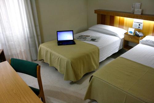 a room with two beds and a laptop on a table at Pacoche Murcia in Murcia