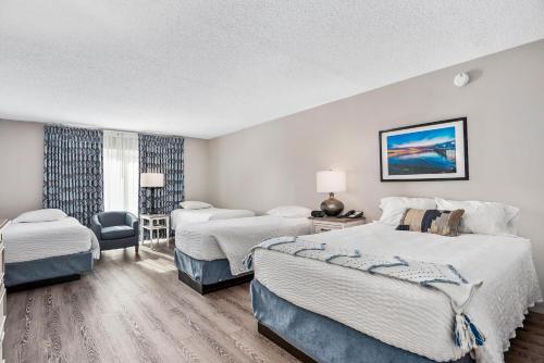 una habitación de hotel con dos camas y una silla en Second East Family Deluxe, en North East