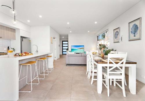 a kitchen and dining room with a table and chairs at Shallows Coastal Retreat in Shellharbour