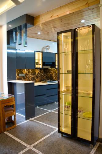 a kitchen with a refrigerator and blue cabinets at The valley gaze in Rājpur