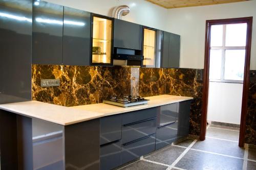 a kitchen with a counter with a stove in it at The valley gaze in Rājpur
