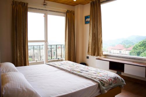 a bedroom with a bed and a large window at The valley gaze in Rājpur