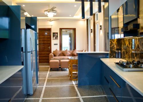 a kitchen with blue cabinets and a living room at The valley gaze in Rājpur