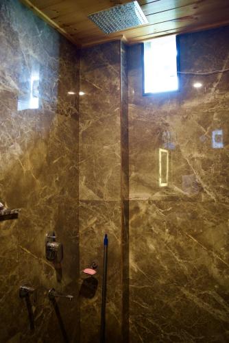 a bathroom with a shower with a glass door at The valley gaze in Rājpur