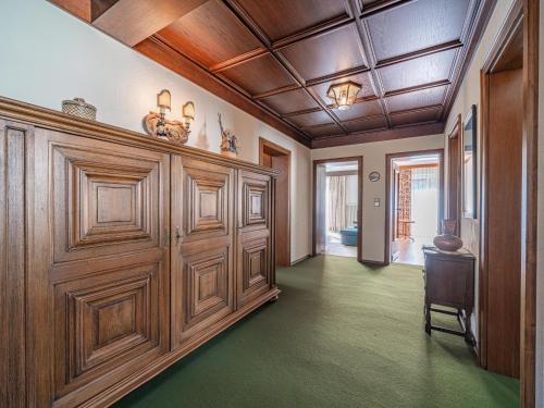 a large room with wooden doors and green floors at Antonia in Neukirchen am Großvenediger