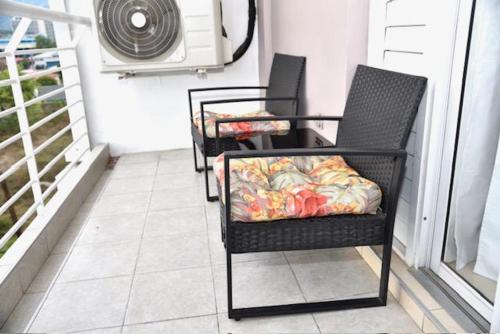 two chairs sitting on a porch with a fan at The Brompton's Luxury Apartment in Kingston