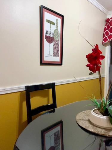 a table with a vase with a red flower on it at The Brompton's Luxury Apartment in Kingston