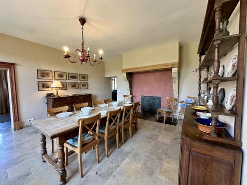 a dining room with a wooden table and chairs at Les Forges dOrval in Abbaye dʼOrval