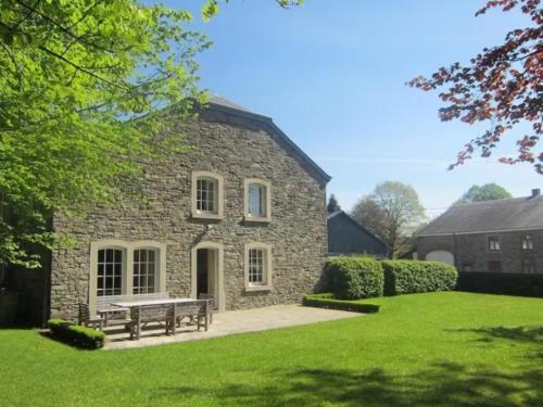 a stone house with a bench in the yard at Le Clos du Parc in Offagne