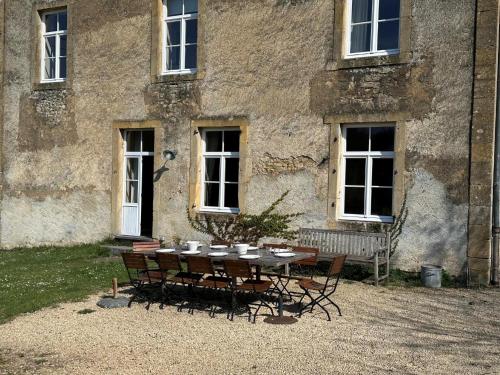 a table and chairs in front of a building at Les Forges dOrval in Abbaye dʼOrval