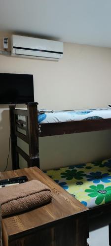 a room with two bunk beds and a table with a desk at Rincon Samario in Santa Marta