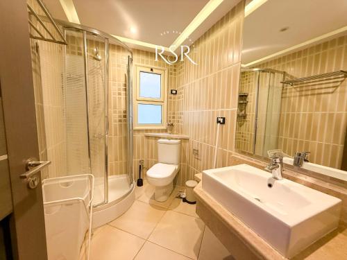 a bathroom with a sink and a toilet and a shower at Elite Suites Hurghada in Hurghada