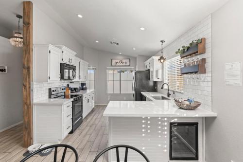 a kitchen with white cabinets and a white counter top at Desert Tails! Most Pet Friendly Pool & Fire Pit in Chandler