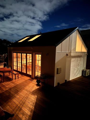 a building with a deck with a table on it at The Orangerie in Hobart