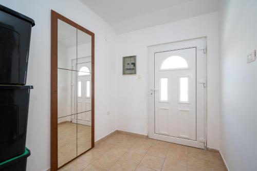 a mirror in front of a door in a room at Apartments with swimming pool Zubovici, Pag - 9365 in Zubovići