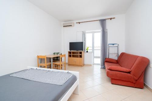 a living room with a red chair and a television at Studio Zubovici 9365a in Zubovići