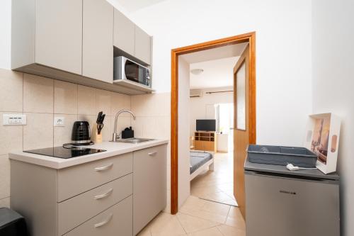 a small kitchen with a sink and a refrigerator at Studio Zubovici 9365a in Zubovići